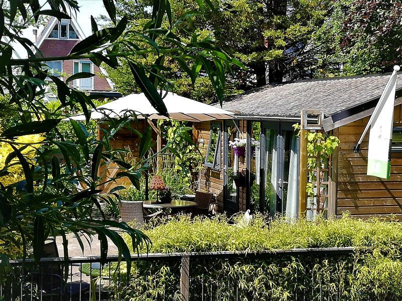 Buitenaanzicht bed en breakfast de zes wielen met veel groen om het huisje